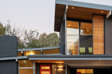 Idée de décoration pour une façade de maison grise vintage en bois de taille moyenne et à niveaux décalés.