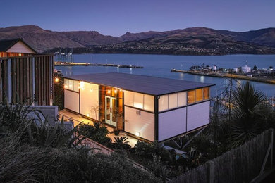Kleines, Einstöckiges Stilmix Einfamilienhaus mit Metallfassade, grauer Fassadenfarbe, Flachdach und Blechdach in Christchurch