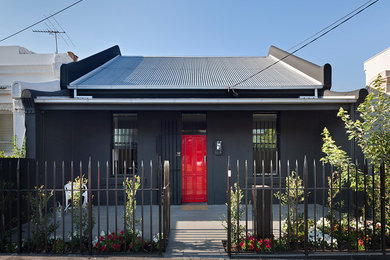На фото: черный дом в современном стиле с двускатной крышей с