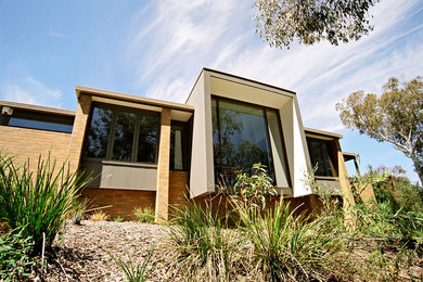 Design ideas for a large and gey modern two floor brick detached house in Canberra - Queanbeyan with a flat roof.
