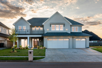 Example of a transitional gray two-story stucco exterior home design in Oklahoma City with a shingle roof