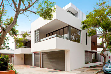 Inspiration för stora moderna vita flerfamiljshus, med två våningar, blandad fasad och platt tak