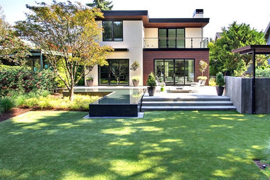 Imagen de fachada de casa multicolor contemporánea grande de dos plantas con revestimientos combinados y tejado plano
