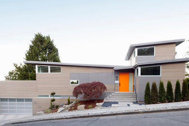 Foto de fachada gris actual a niveles con revestimientos combinados