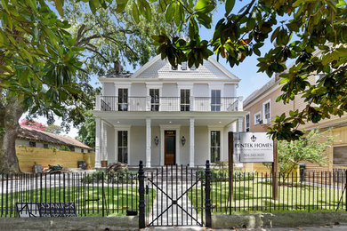 Example of a large classic gray three-story wood exterior home design in New Orleans with a hip roof