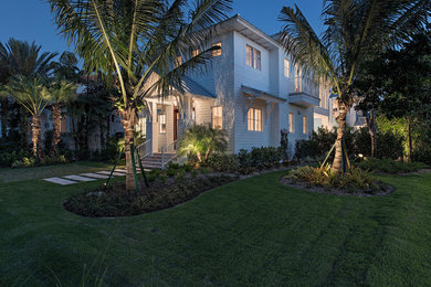 Large transitional white two-story concrete fiberboard exterior home photo in Miami with a hip roof