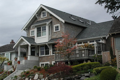 Large elegant brown two-story wood exterior home photo in Seattle with a shingle roof