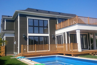 Diseño de fachada gris actual extra grande a niveles con revestimiento de madera y tejado a cuatro aguas