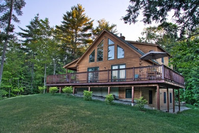 Large mountain style brown three-story wood exterior home photo in Portland Maine with a clipped gable roof