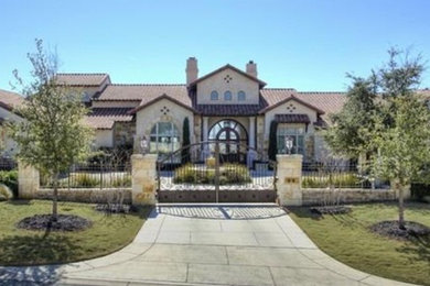Example of a large tuscan one-story stone exterior home design in Austin with a tile roof