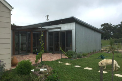 Foto de fachada de casa contemporánea de tamaño medio de una planta con revestimientos combinados, tejado a cuatro aguas y tejado de metal