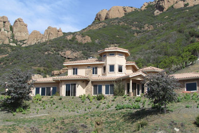 Idee per la facciata di una casa grande beige mediterranea a due piani con rivestimento in stucco e tetto a padiglione