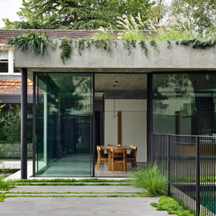 Modelo de fachada de casa gris, grande, de una planta, con revestimiento de hormigón, tejado plano y techo verde
