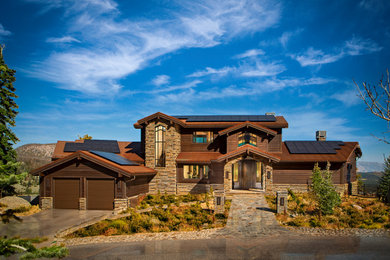Foto de fachada de casa marrón rural de dos plantas con revestimientos combinados y tejado a dos aguas