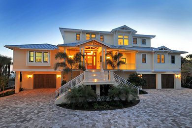 Large coastal beige three-story wood exterior home idea in Other