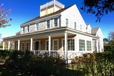 Huge beach style gray two-story wood exterior home photo in Boston with a hip roof