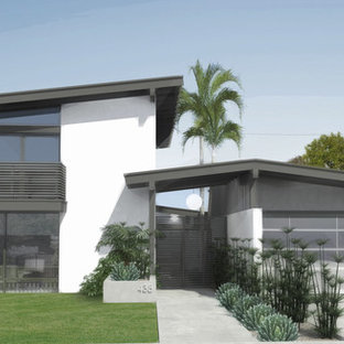 Mid-sized mid-century modern white two-story stucco exterior home photo in Los Angeles with a hip roof