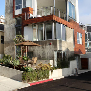Modelo de fachada de casa multicolor, minimalista, grande, de tres plantas, con revestimiento de hormigón y tejado plano