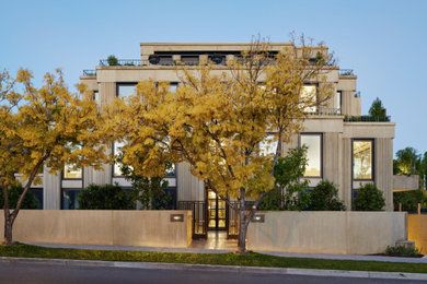 Großes, Dreistöckiges Modernes Haus mit beiger Fassadenfarbe, Flachdach und Putzfassade in Melbourne