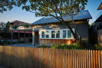 Foto della villa grigia contemporanea a due piani con rivestimento in legno, tetto a capanna e copertura in metallo o lamiera