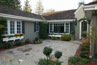 Exemple d'une façade de maison verte chic en stuc de taille moyenne et de plain-pied avec un toit à deux pans et un toit en shingle.