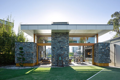 Пример оригинального дизайна: одноэтажный, серый дом среднего размера в стиле модернизм с облицовкой из камня и плоской крышей