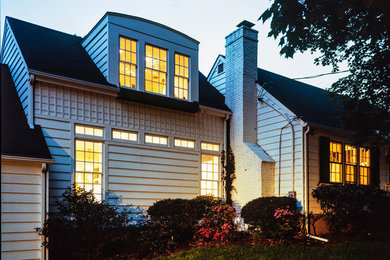 Medium sized and white traditional bungalow house exterior in New York with vinyl cladding.