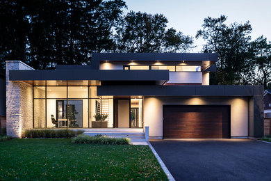 Large modern gray two-story stucco exterior home idea in Toronto with a mixed material roof