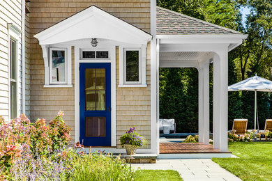 This is an example of a medium sized and blue beach style two floor house exterior in Boston with wood cladding.