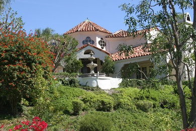 Großes, Zweistöckiges Mediterranes Haus mit Putzfassade, beiger Fassadenfarbe und Satteldach in Los Angeles