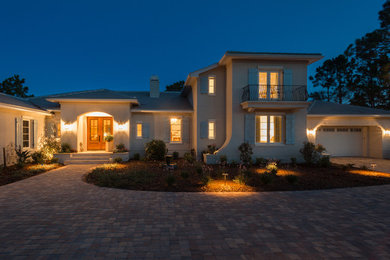Large elegant beige two-story stucco house exterior photo in Jacksonville with a hip roof and a shingle roof