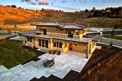 Foto della villa grande beige contemporanea a due piani con rivestimenti misti, tetto piano e copertura in metallo o lamiera