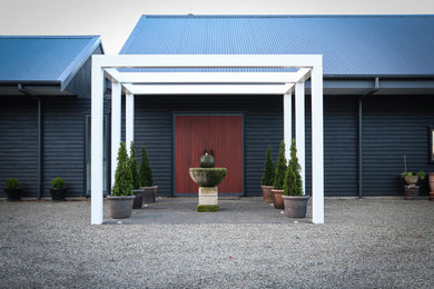 Immagine della facciata di una casa grande nera contemporanea a due piani con rivestimento in legno, tetto a capanna e copertura in metallo o lamiera