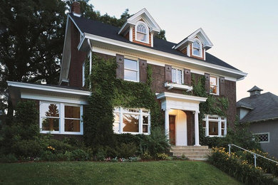 Стильный дизайн: большой, двухэтажный, кирпичный, коричневый дом в классическом стиле с двускатной крышей - последний тренд