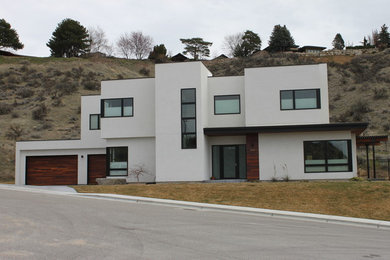 Aménagement d'une grande façade de maison blanche moderne en stuc à un étage avec un toit plat et un toit végétal.