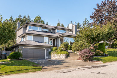 Mid-sized transitional gray three-story stucco house exterior idea in Vancouver with a shingle roof