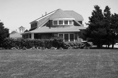 Mid-sized beach style gray three-story wood house exterior photo in Boston with a clipped gable roof and a shingle roof