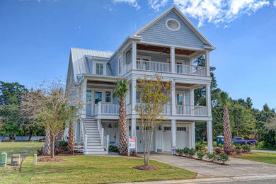 Example of a large beach style blue three-story wood exterior home design in Wilmington with a metal roof