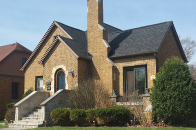 Mid-sized traditional brown one-story stone gable roof idea in Chicago