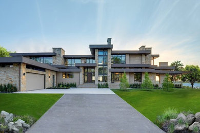 Ejemplo de fachada de casa beige minimalista grande de dos plantas con revestimientos combinados y tejado plano