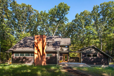 Diseño de fachada marrón moderna de tamaño medio de dos plantas con revestimientos combinados y tejado a dos aguas