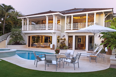 Modelo de fachada blanca tropical de tamaño medio de dos plantas con revestimiento de vinilo y tejado a cuatro aguas