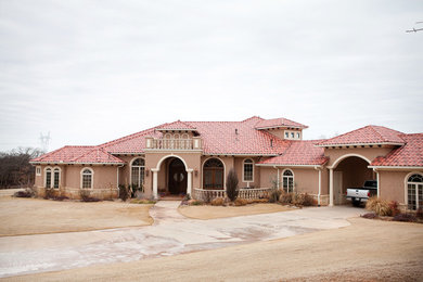 Huge southwest brown two-story adobe exterior home photo in Oklahoma City with a hip roof