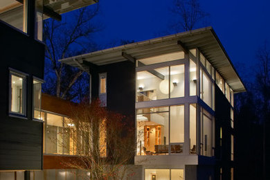Inspiration for a large contemporary gray three-story wood house exterior remodel in Other with a shed roof and a metal roof
