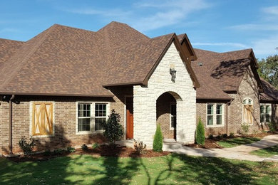 Inspiration for a large transitional brown two-story mixed siding exterior home remodel in Oklahoma City with a hip roof