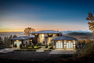 Huge trendy beige three-story stucco house exterior photo in Vancouver with a hip roof and a metal roof