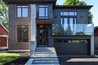 Foto della facciata di una casa grigia contemporanea a due piani con rivestimento in legno e tetto a padiglione