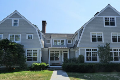 Large elegant beige three-story wood house exterior photo in Manchester with a gambrel roof and a shingle roof