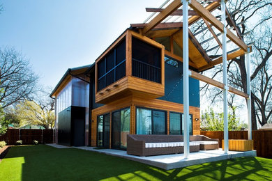 Foto de fachada de casa marrón contemporánea de dos plantas con revestimientos combinados y tejado a dos aguas