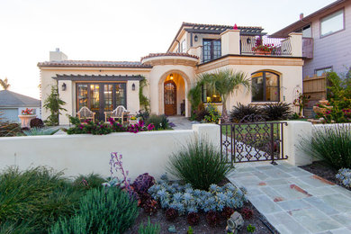 Example of a mid-sized tuscan beige two-story stucco exterior home design in San Luis Obispo with a hip roof